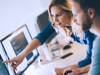Personas programando en una hoja de código.